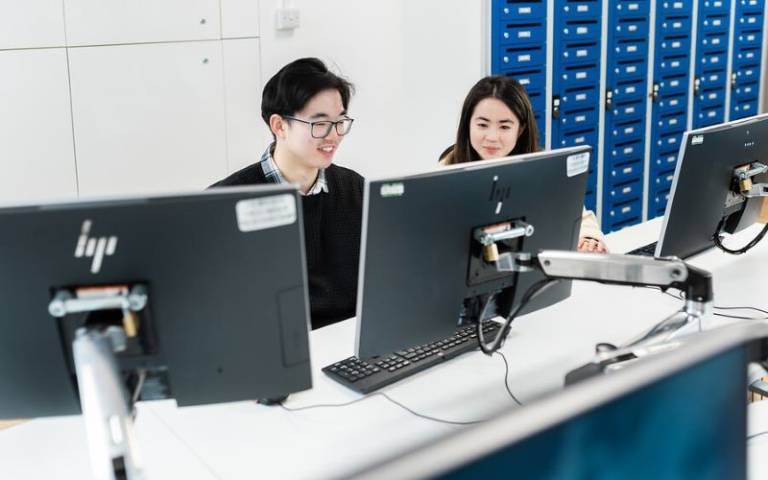 two students working at desktop computers