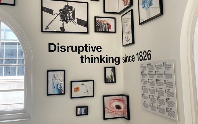 The interior of the North Lodge, displaying a selection of UCL research images and a sign "Disruptive thinking since 1826"