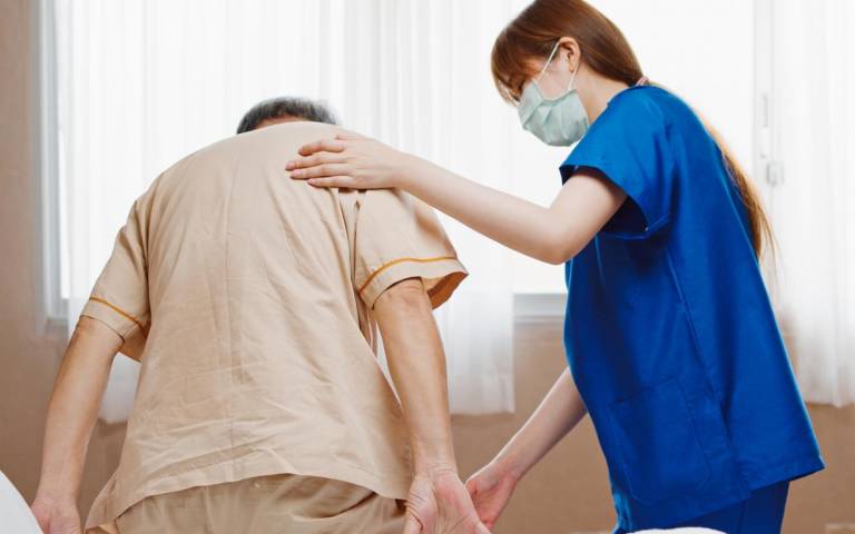 nurse helps elderly man