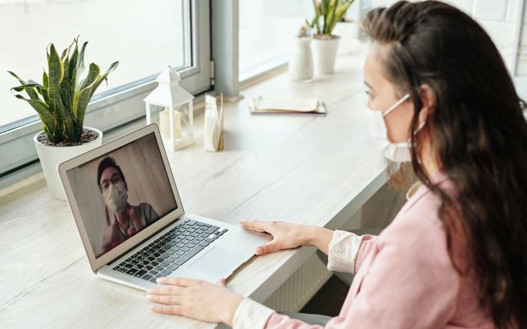 Woman in a facemask video calling