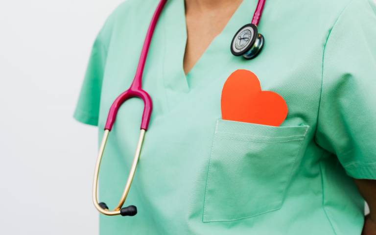 cut out red heart in a pocket of a healthcare worker