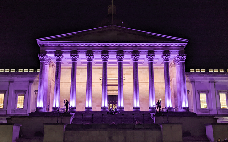 The UCL Portico lit purple at night