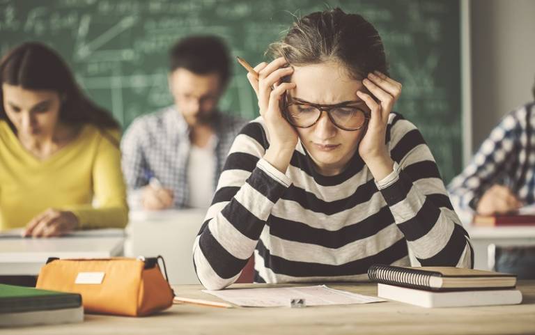 Image shows a girl in class looking frustrated