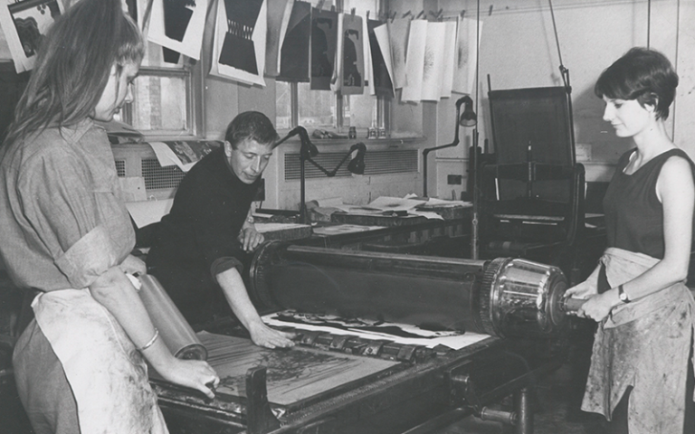 Heritage black and white image of three people working in the Slade print shop