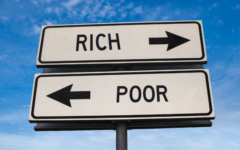 rich and poor road signs with arrows pointing in opposite directions