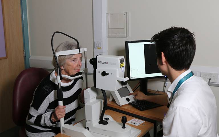 Siegfried Wagner giving a patient with Parkinson's an OCT eye scan