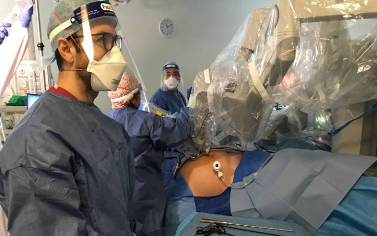 Surgeons at UCLH wear full PPE to control a robot designed to remove a patient's prostate cancer