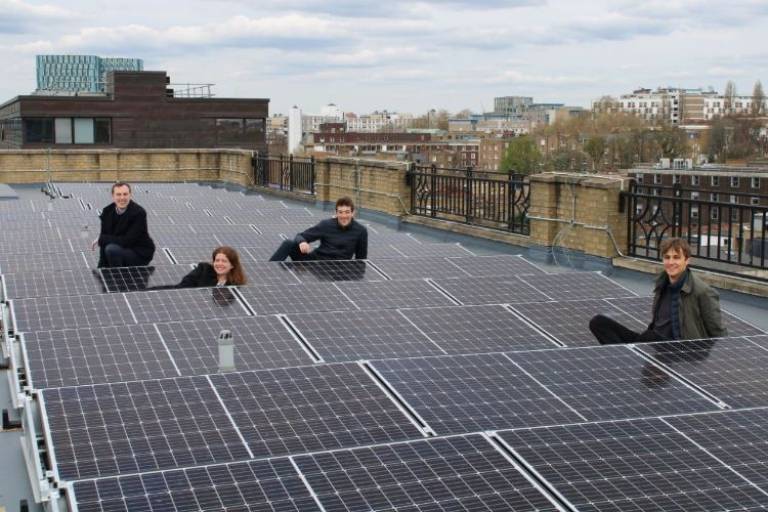 People sitting on a roof full of solar panels