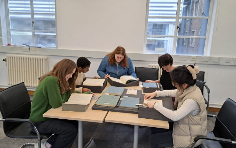 student project team at work with documents from special collections