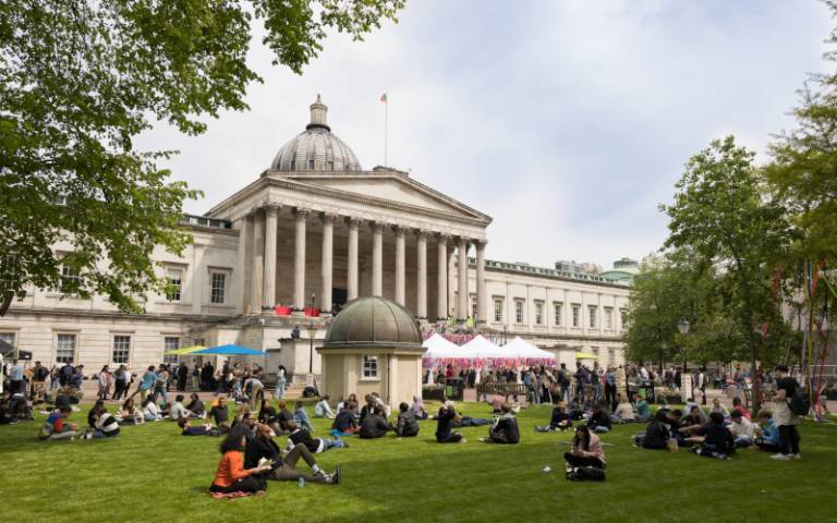 Am image showing UCL's Quad in the Summer during our annual summer celebration, with people relaxing on thw lawn in the foreground.