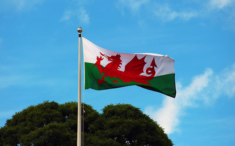 An image of a Welsh flag against a blue sky