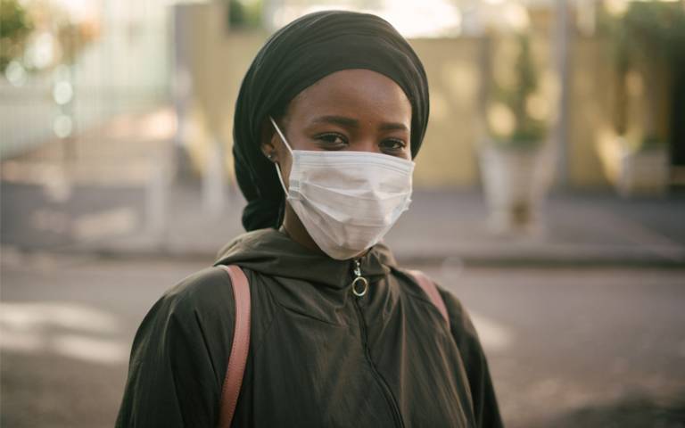 ‘African-American woman in facemask on city street’ 