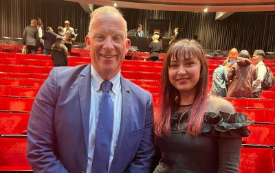 Arifa with the Provost Michael Spence in an auditorium. 