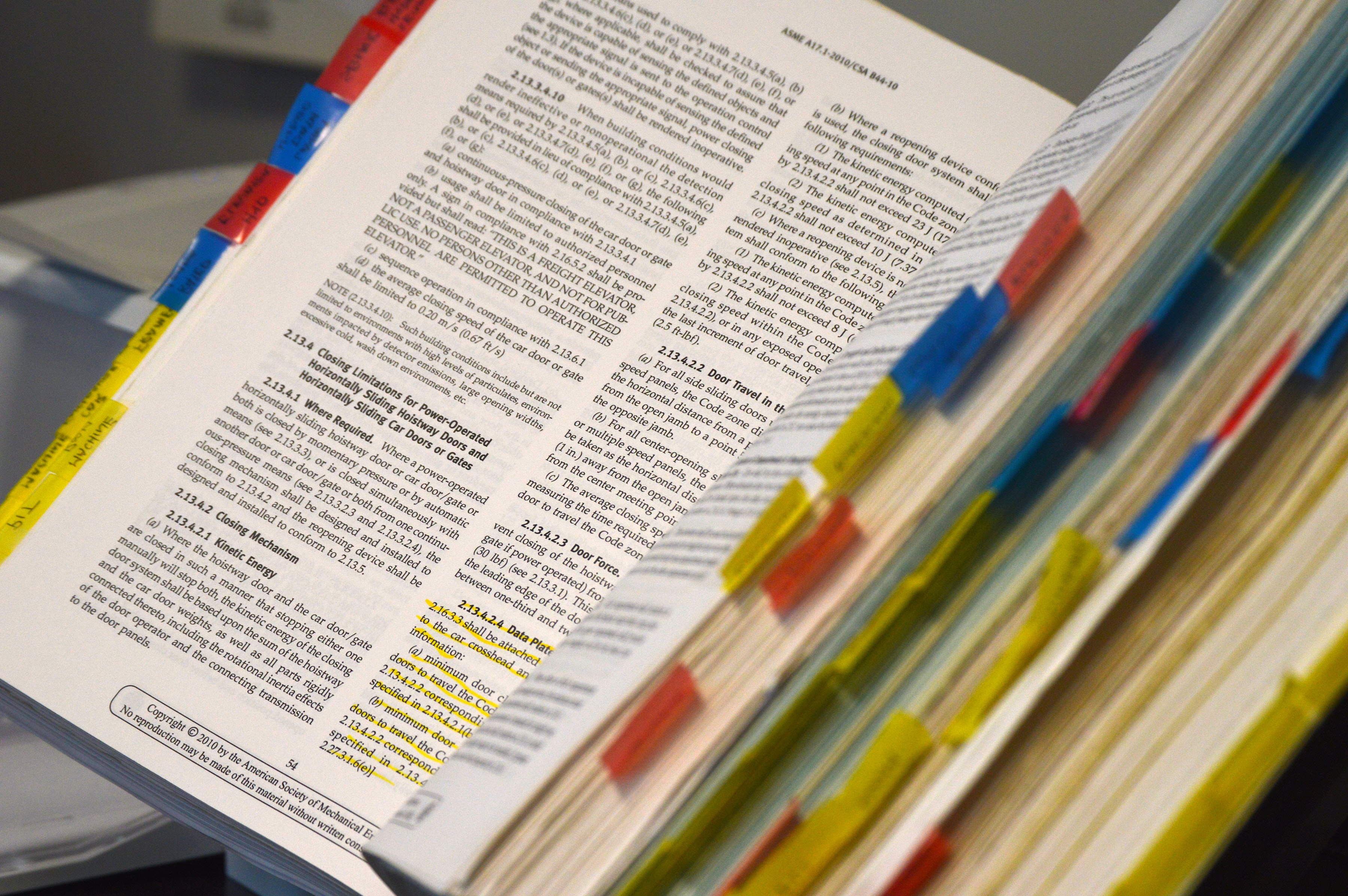 A textbook with highlighted and bookmarked pages