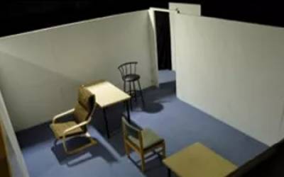 An empty room with a chair, table and blue floor