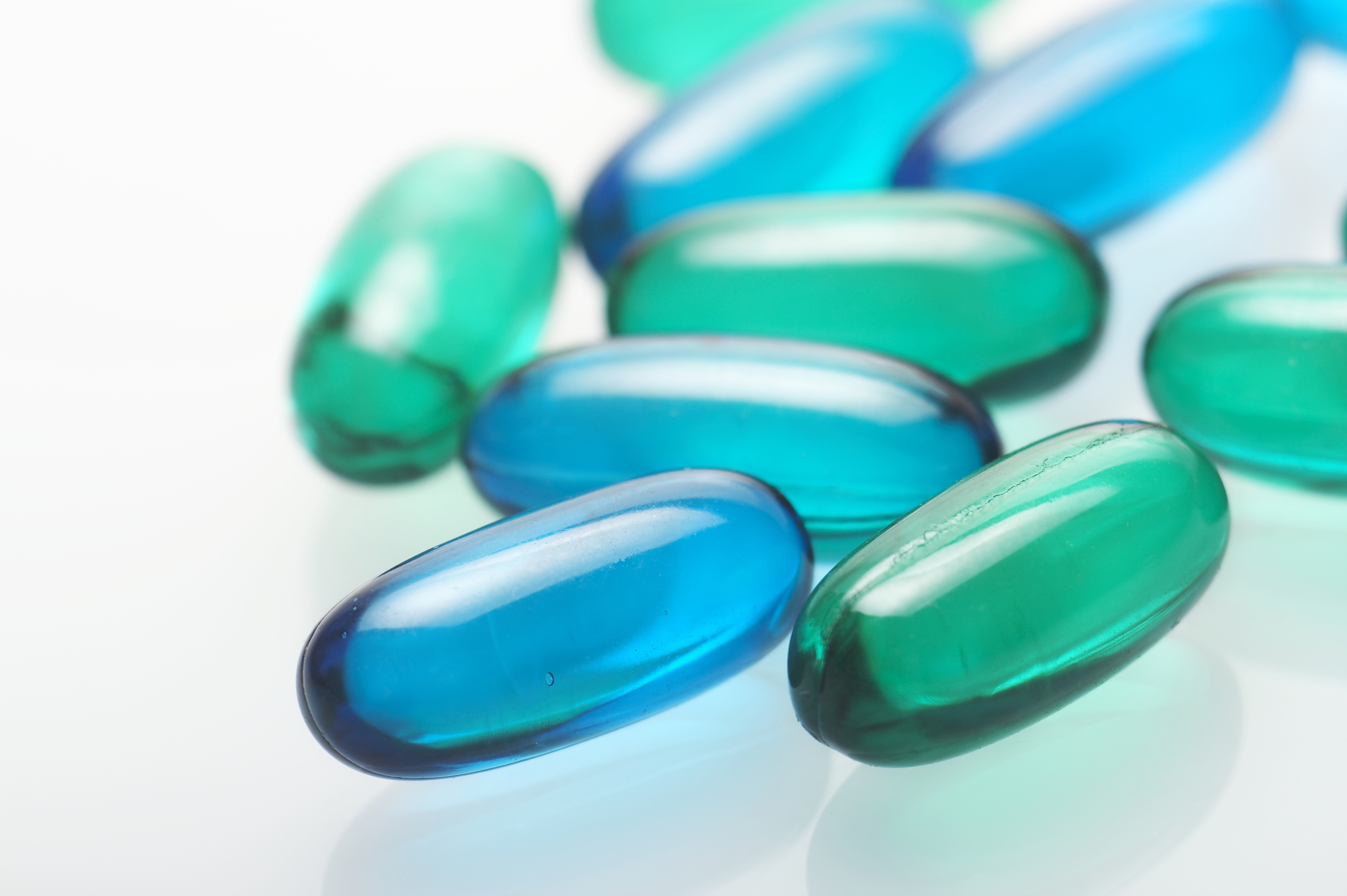 Various pills in blue and green hues.