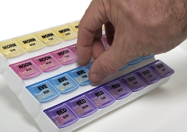 Patient putting pills into a pill box