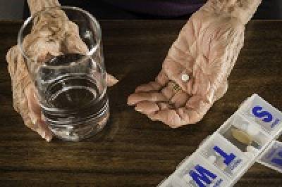 Arthritic hands taking medicines