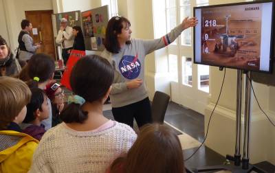 Karen Devoil explains the robotic exploration of Mars using images on a television screen to a group of school children at UCL's Your Universe Festival 2020