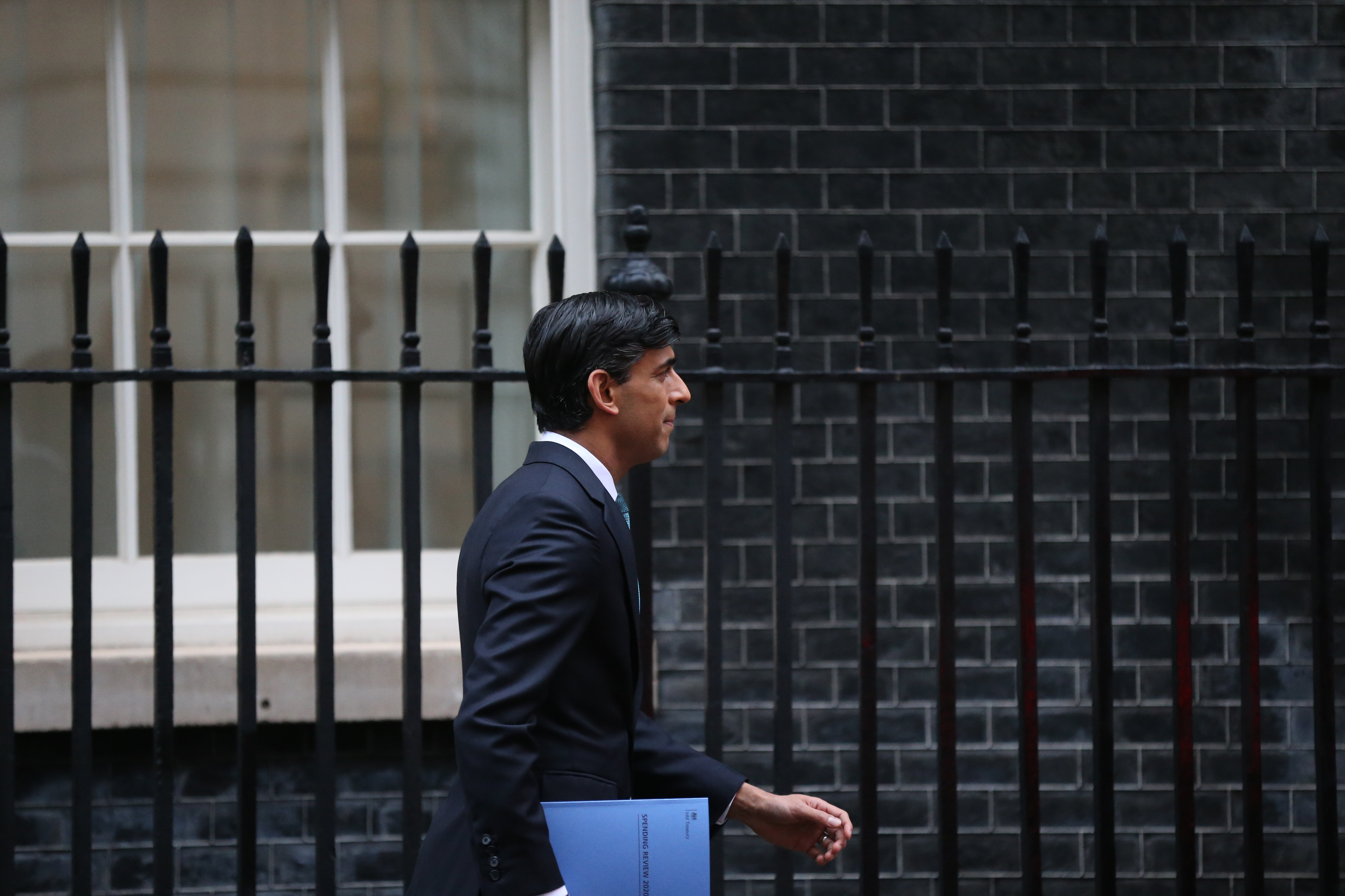 Rishi Sunak walking by Downing Street holding a folder