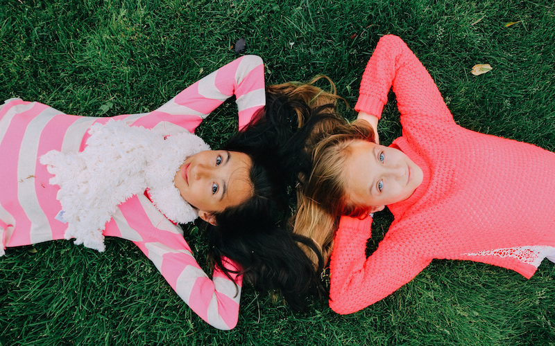 girls lying on the grass
