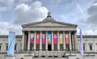 The UCL Portico on a grey day. There are colourful banners hanging down saying Welcome.