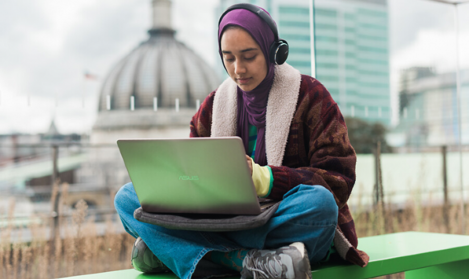 A student works on a laptop on the roof terrace of the UCL students centre.