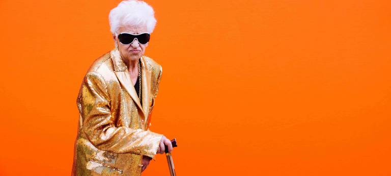 elderly lady in front of orange background