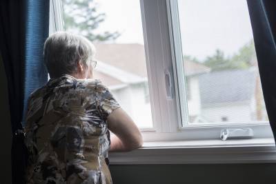 Photo of elderly lady looking out of a window