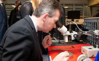 Jeremy Wright peering down a microscope.