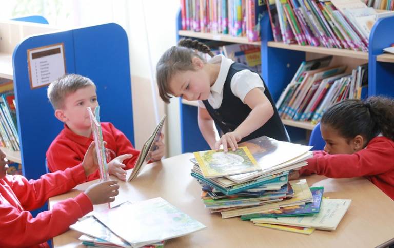 group of children sitting at the table and select books to read during the guided reading activity