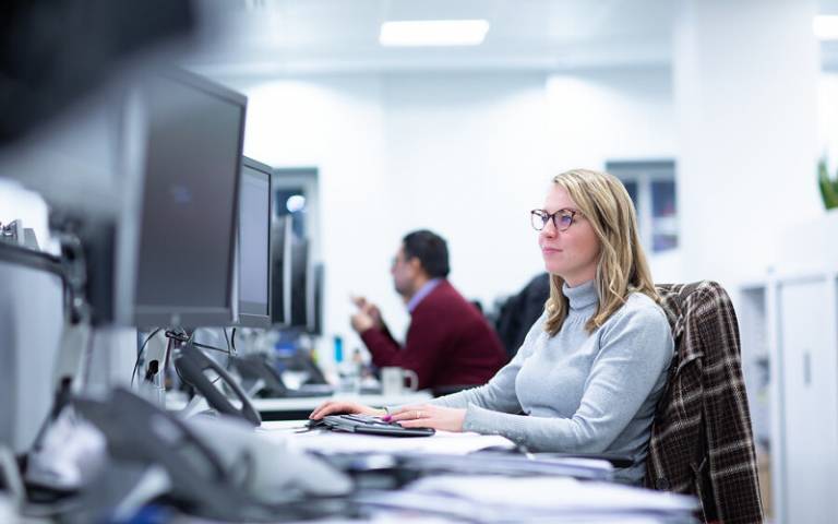 Woman sitting at desk looking at a computer screen