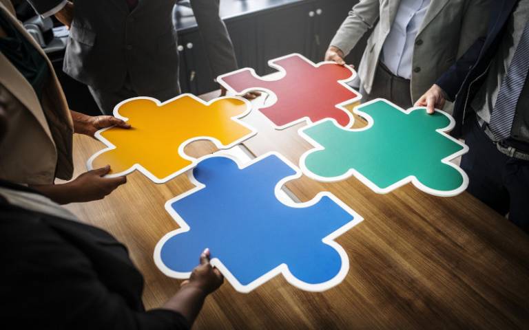 People holding large jigsaw pieces