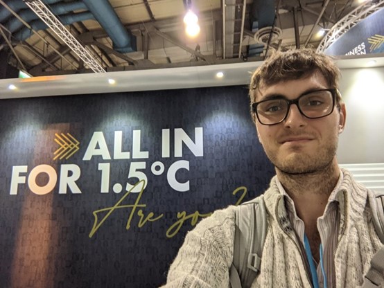 Robbie Mallet standing infront of 1.5 degree sign at COP26