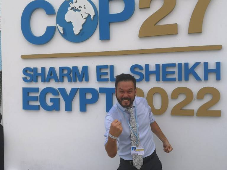 simon stands in front of COP27 Sharm El-Sheikh sign