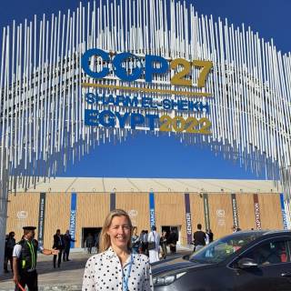 Nicola stands in frnt of COP27 sign