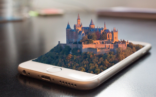 a mobile phone with a digital castle coming out of the screen