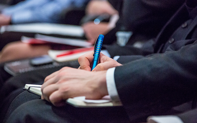 an image of a man in a suit writing on a notebook