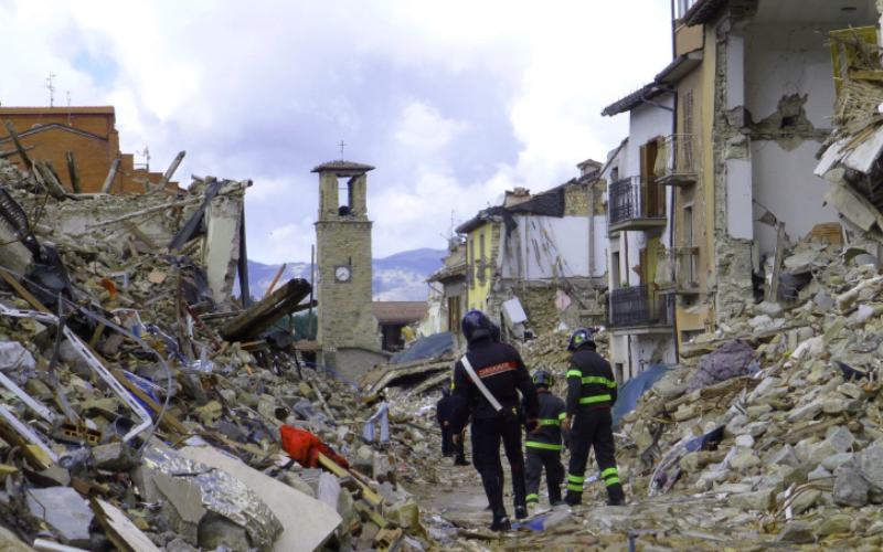 Response personnel walking through rubble