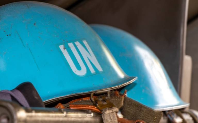 UN peacekeeper helmets on a shelf