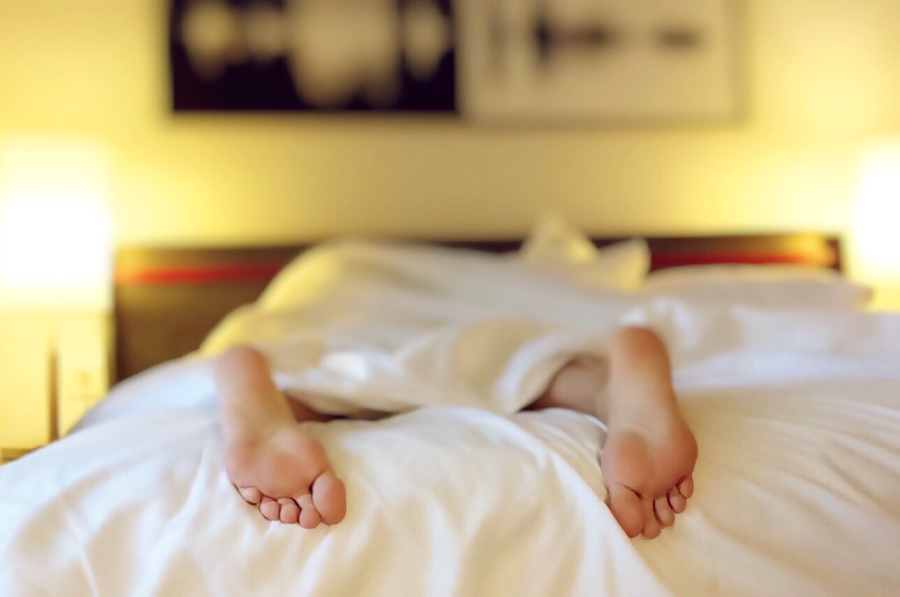Feet poking out of white bed sheets