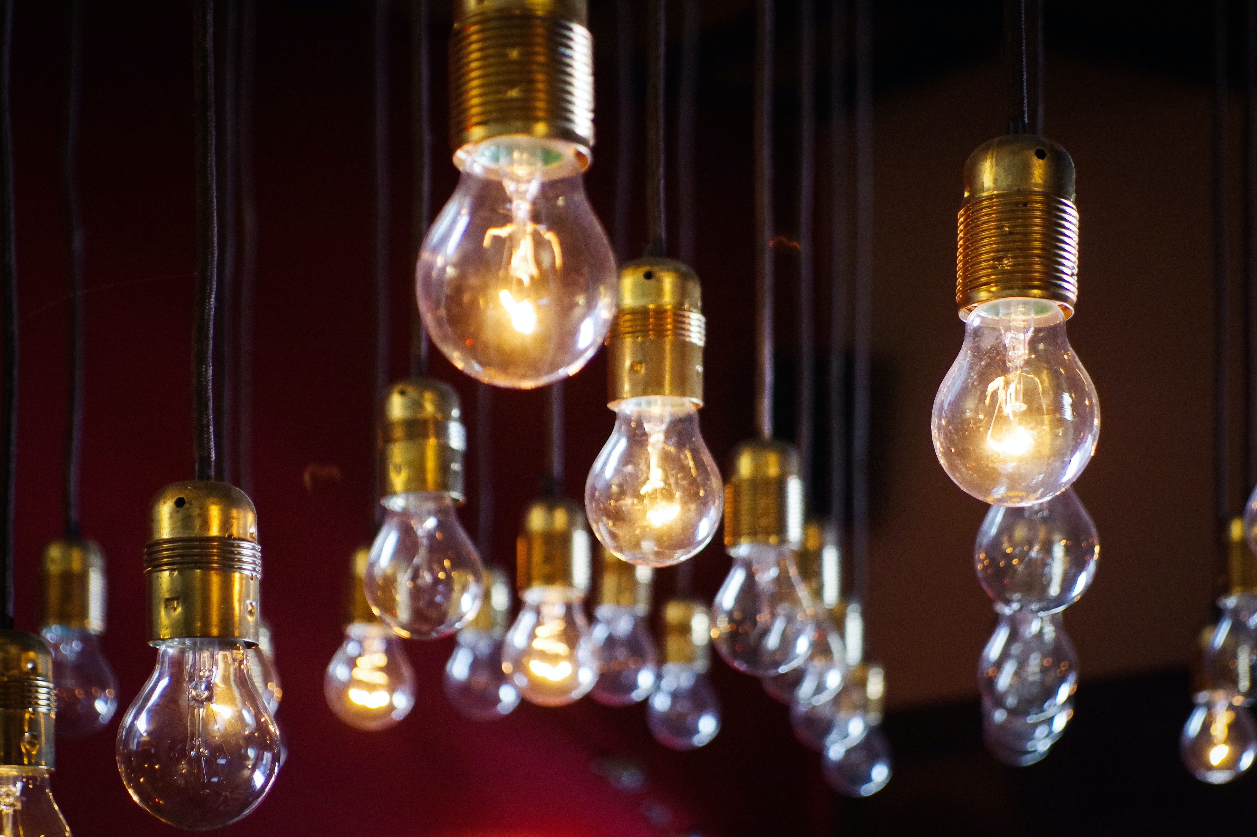 Glowing lightbulbs hanging on pendants against a dark background
