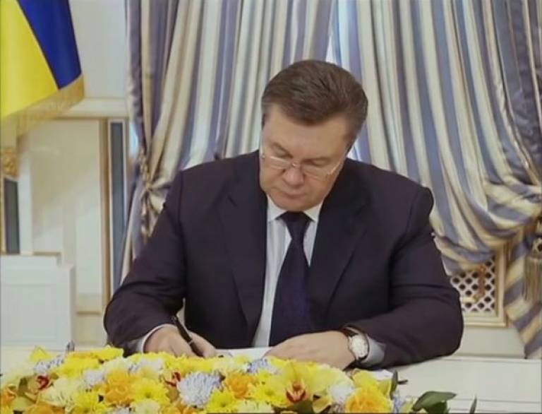 President of Ukraine Viktor Yanukovych signing agreement on the solution of the crisis with opposition