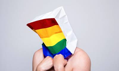 Image of man with rainbow bag on his head (photographer Christa Holka)