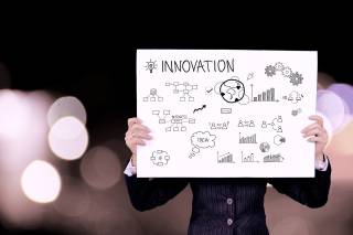 Image of a person holding up an 'innovation' sign