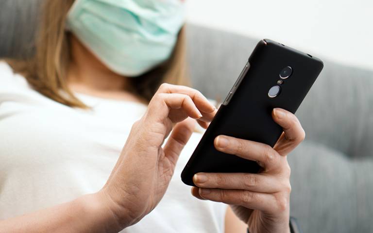 Woman with smartphone and face mask