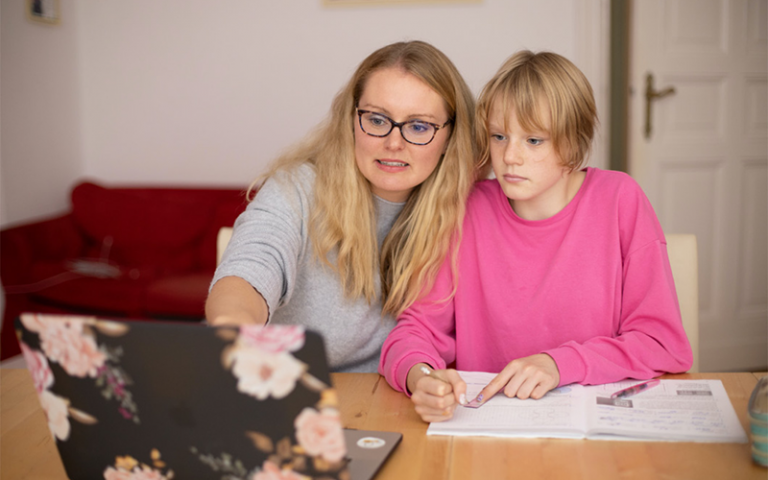 Adult woman teaching young girl at home