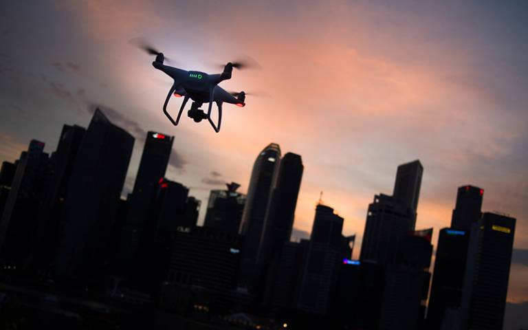 Drone flying over city at dusk