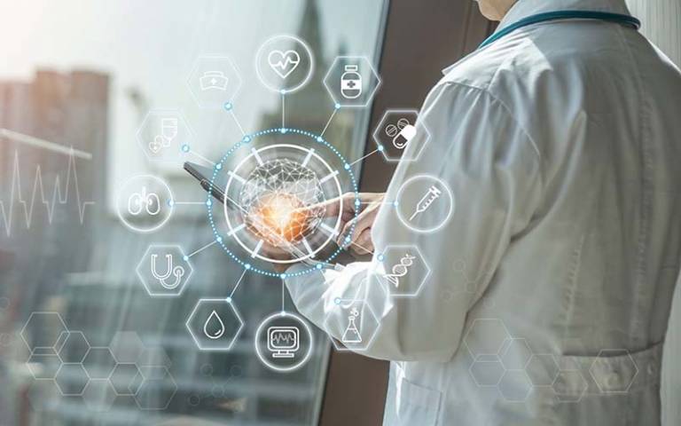 Person in white lab coat using tablet with IoT icons