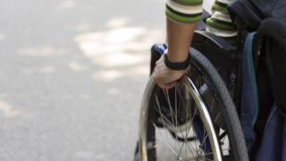 Hand on wheel of wheelchair